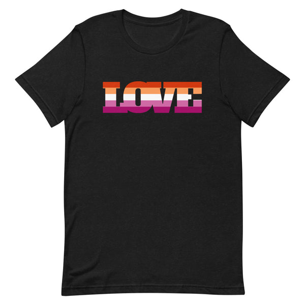Lesbian Love T-Shirt, folded on a beige sofa, with “LOVE” in bold rainbow letters; mug, sunglasses, book “Echoes of the Heart” close by.