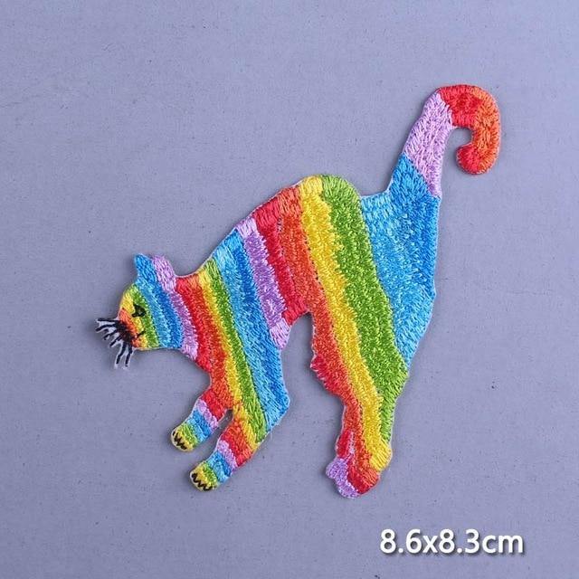 Rainbow-striped lemur embroidered iron-on patch on a lavender background