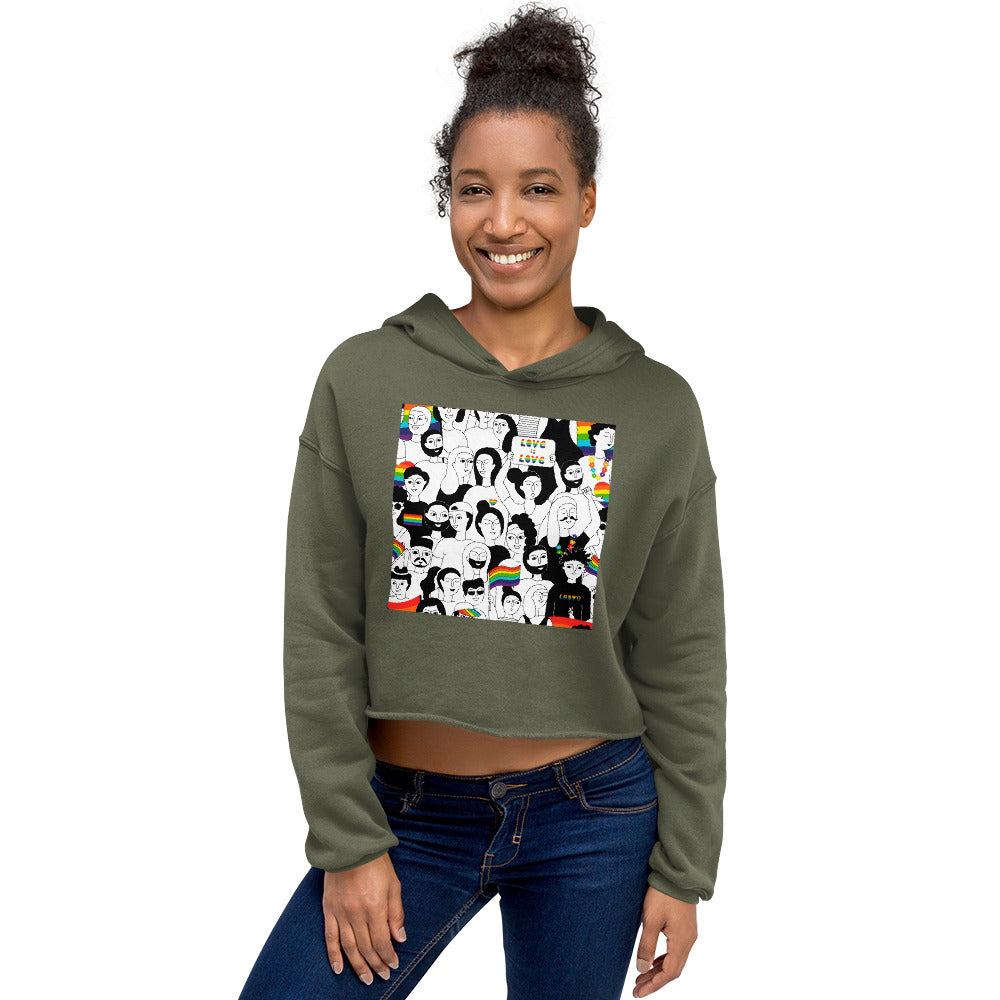 Front-view model wearing an olive cropped hoodie with a colorful illustrated Pride graphic