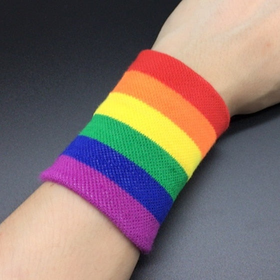Close-up of a rainbow-striped knitted wristband worn on a wrist