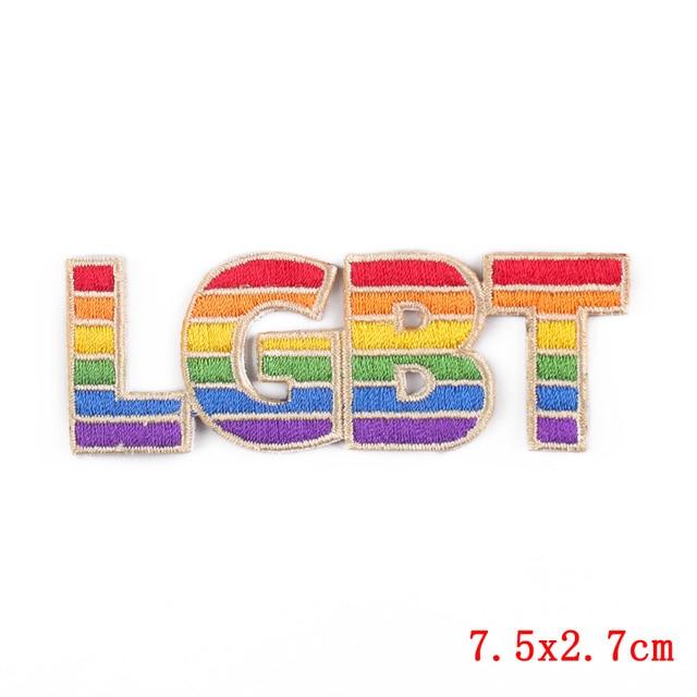 sklep online lgbtqia: Flat lay of rainbow LGBT Pride embroidered iron-on patches, rainbow flags, buttons, beads