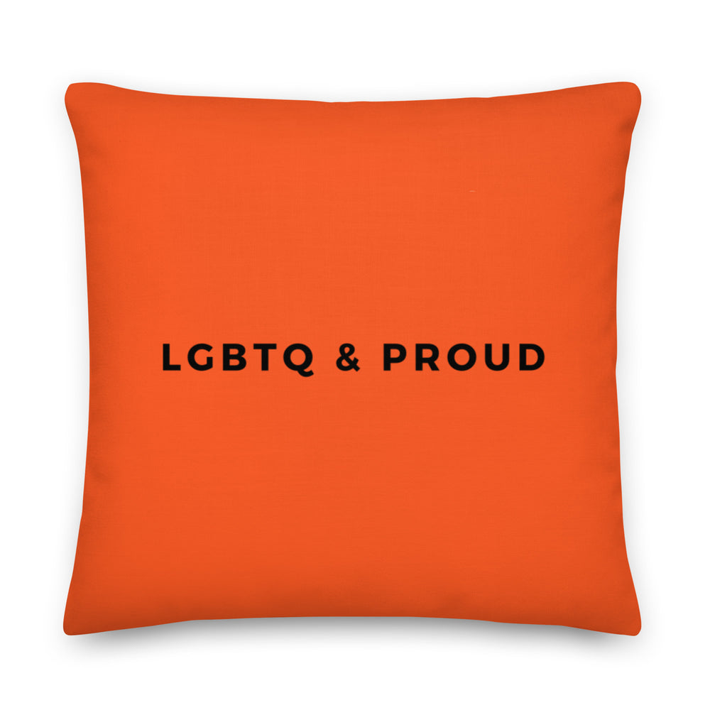 Front view of an orange square pillow reading “LGBTQ & PROUD” in black letters