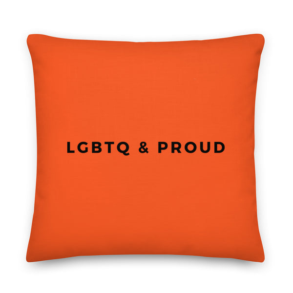 Front view of an orange square pillow reading “LGBTQ & PROUD” in black letters
