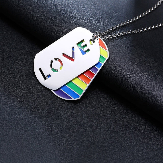 Close-up of a rainbow-striped dog tag necklace with a silver LOVE tag