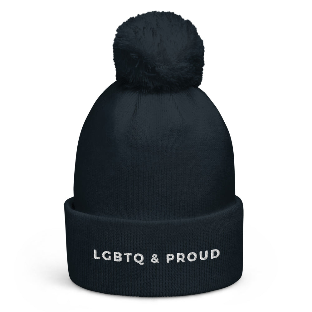 Front view of a dark navy ribbed pom-pom beanie reading “LGBTQ & PROUD”