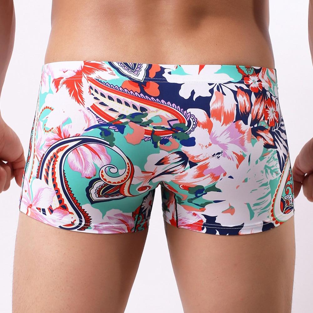 Model wearing colorful floral and paisley print boxer briefs in a close-up front view