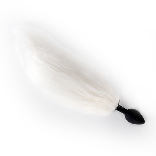 White furry tail attached to a black silicone butt plug, shown diagonally on white