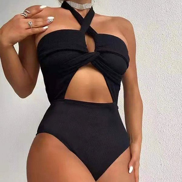 Front-view model wearing a black cutout one-piece swimsuit with a halter neckline