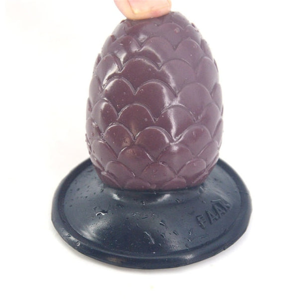 Close-up of a purple, lotus-textured anal plug with a black flared base, held at the top