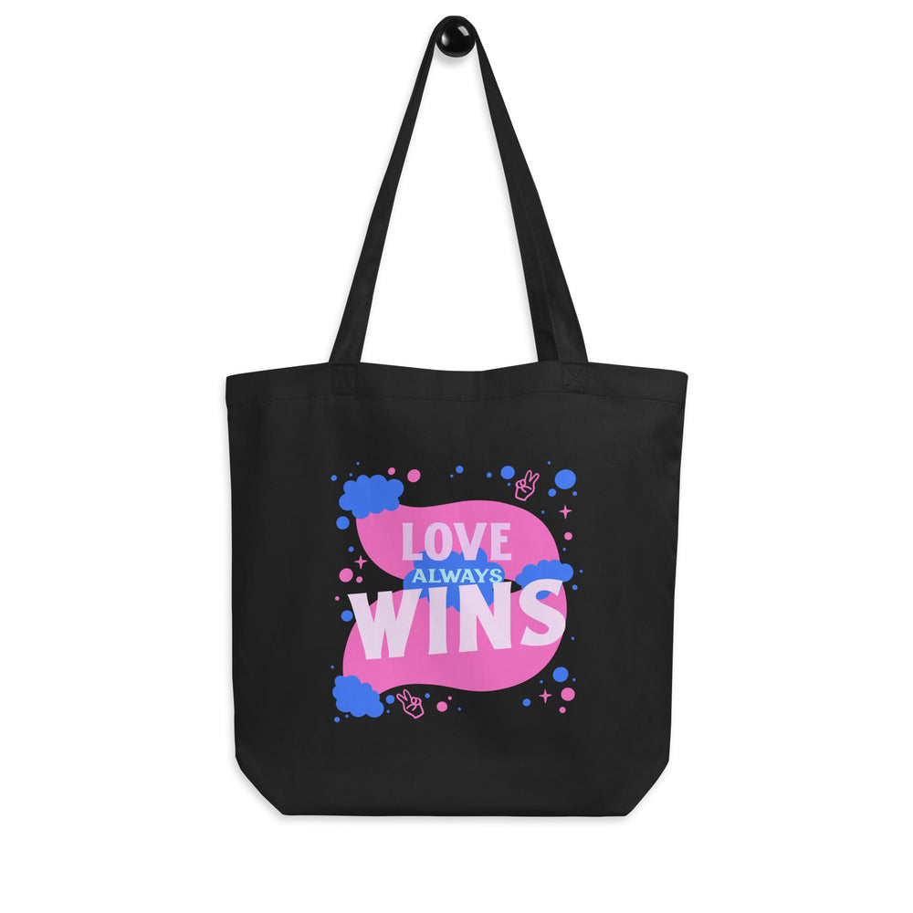 Front view of a black tote bag with pink and blue “LOVE ALWAYS WINS” graphic
