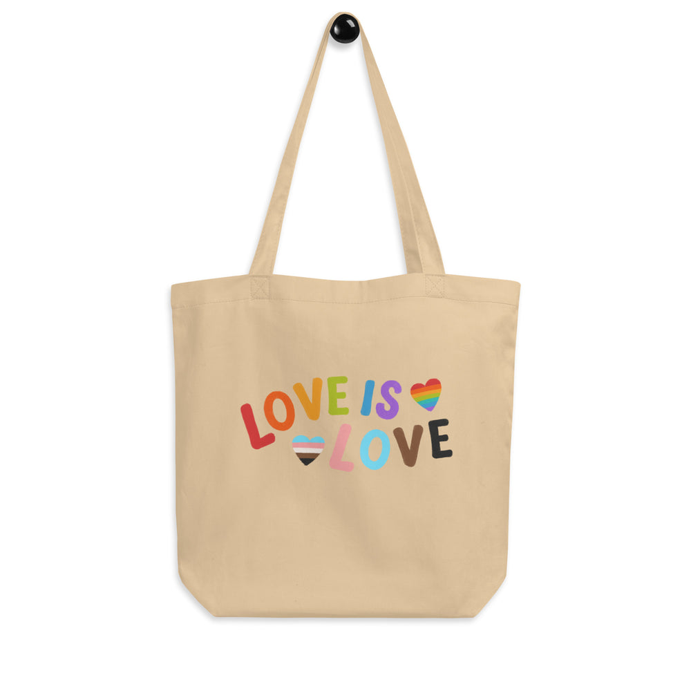 Front view of a natural canvas tote bag reading “LOVE IS LOVE” with rainbow hearts