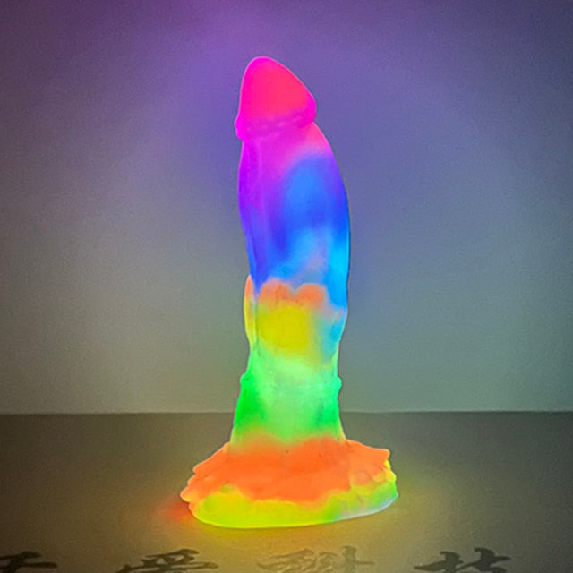 Glow-in-the-dark dragon-shaped dildo standing upright on a suction-cup base