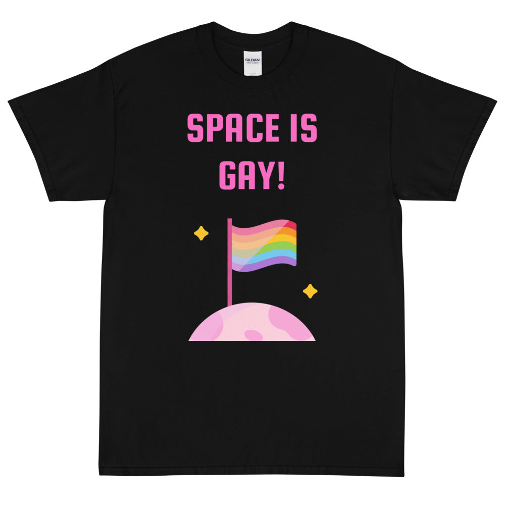 Space Is Gay T-Shirt with “SPACE IS GAY!” and a rainbow planet, worn by queer couple holding hands at dusk with city lights behind.