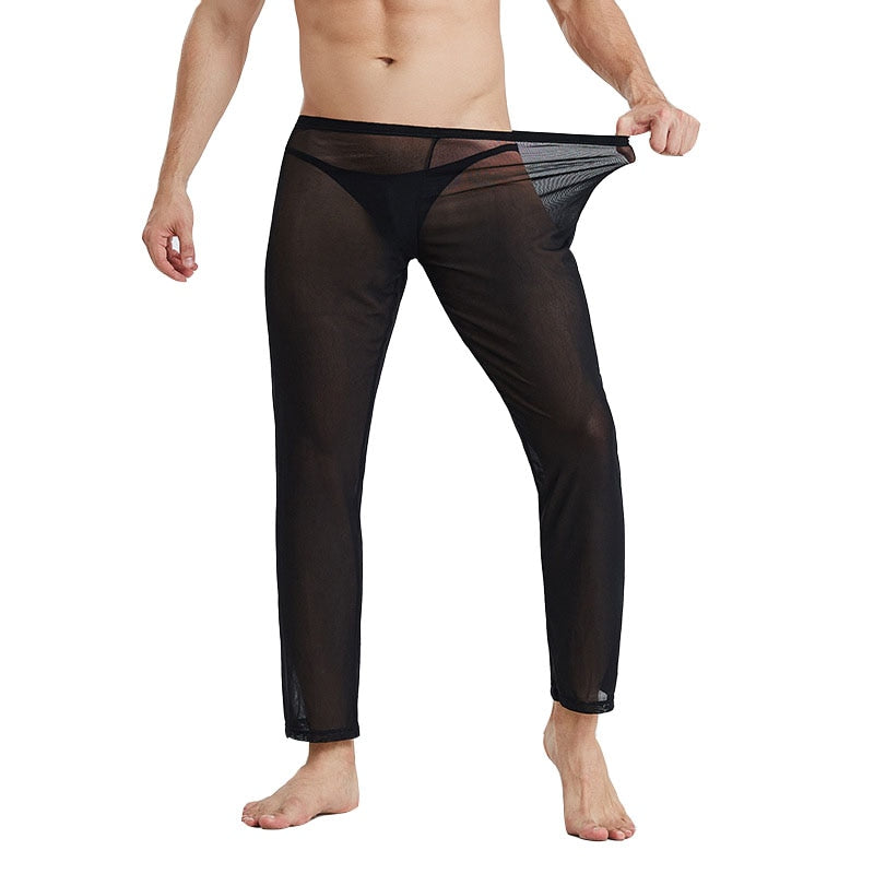 Cropped model wearing black sheer mesh pants, pulling the waistband outward