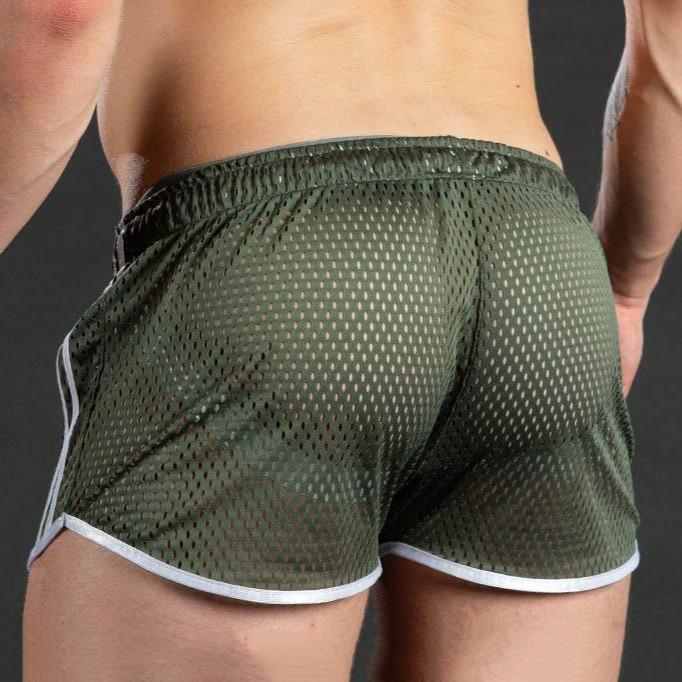 Rear view of a model wearing dark green mesh athletic shorts with white trim