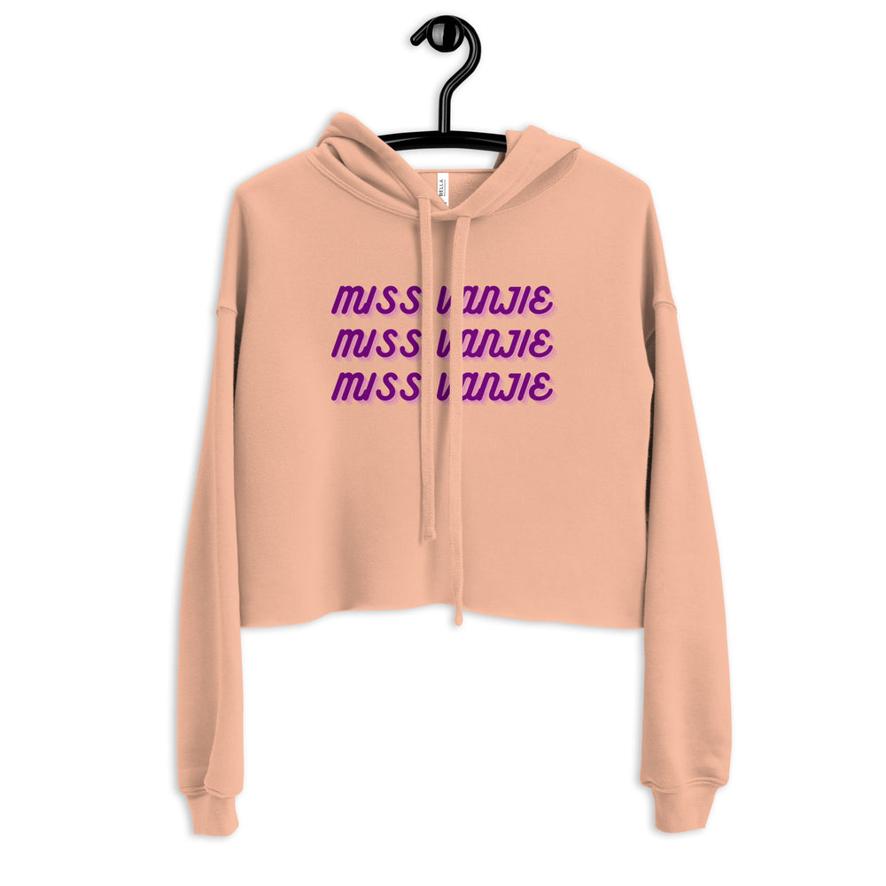 Front view of a peach cropped hoodie with purple “MISS VANJIE” text repeated three times