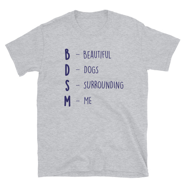 BDSM (Beautiful Dogs Surrounding Me) T-shirt with blue text, bold unisex fit, worn by a young man in a club’s orange-lit crowd.