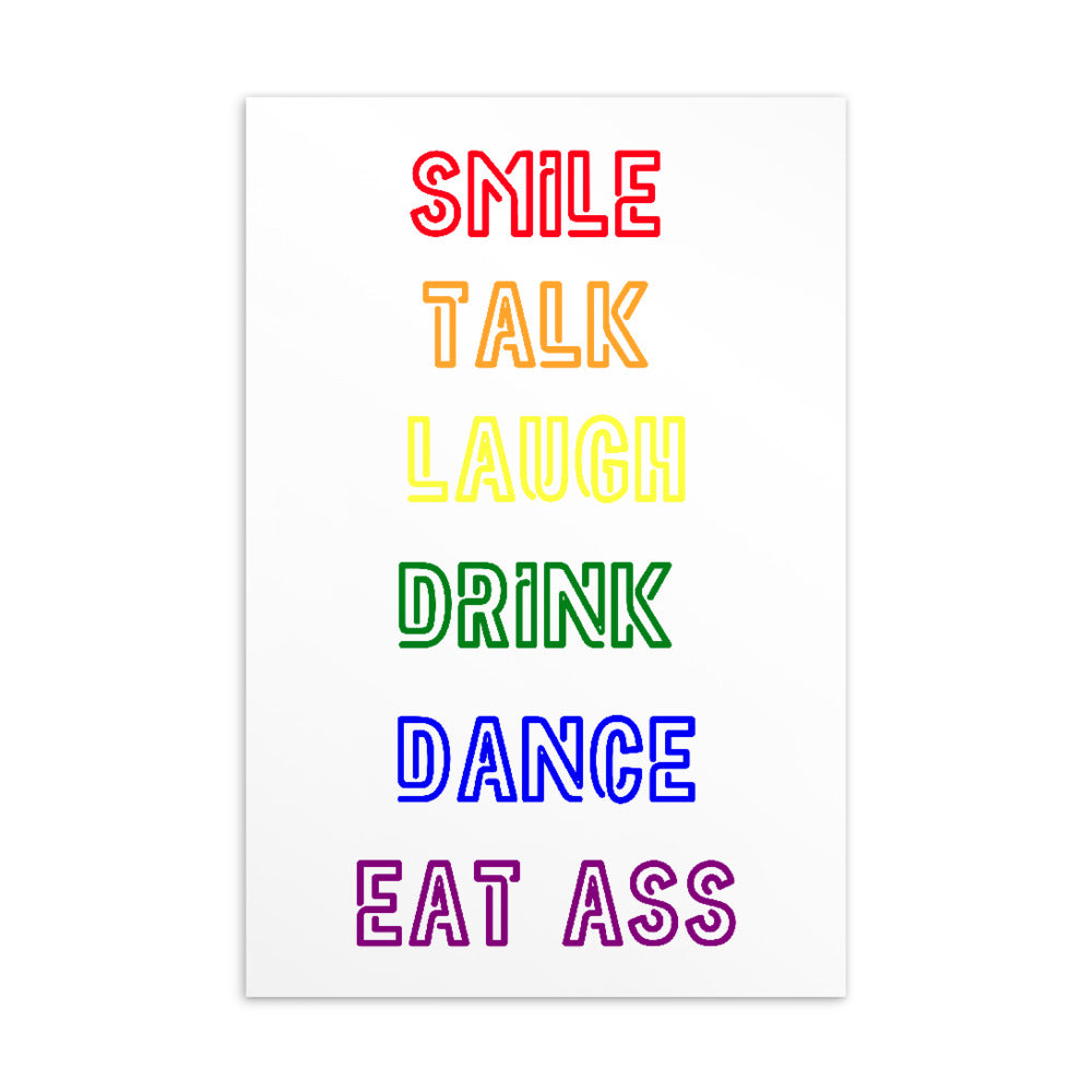 Close-up of a white postcard reading “SMILE TALK LAUGH DRINK DANCE EAT ASS” in rainbow colors