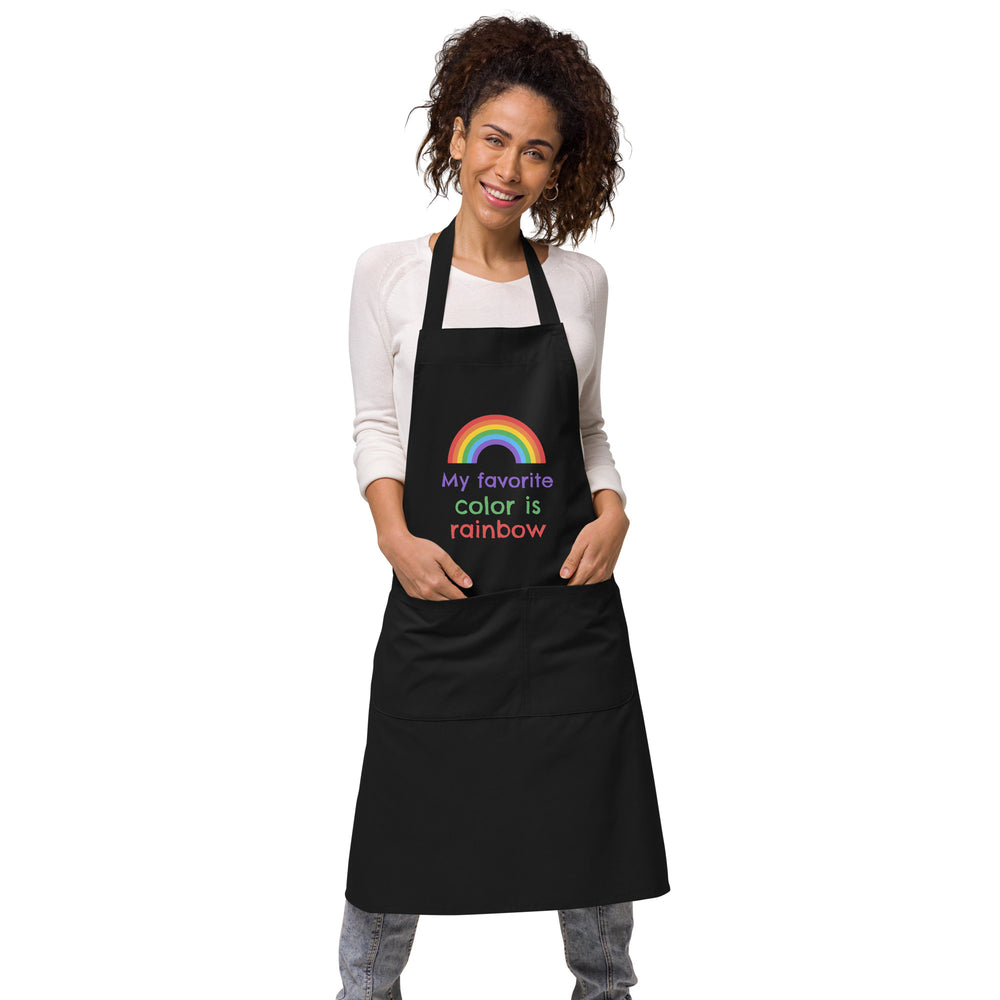 Front-view model wearing a black apron with a rainbow and “My favorite color is rainbow” text
