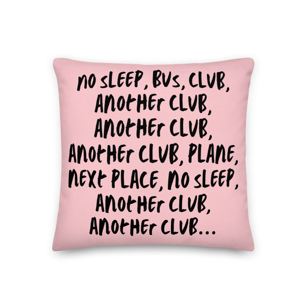 Pink pillow printed with the repeated phrase “NO SLEEP, BUS, CLUB, ANOTHER CLUB…”