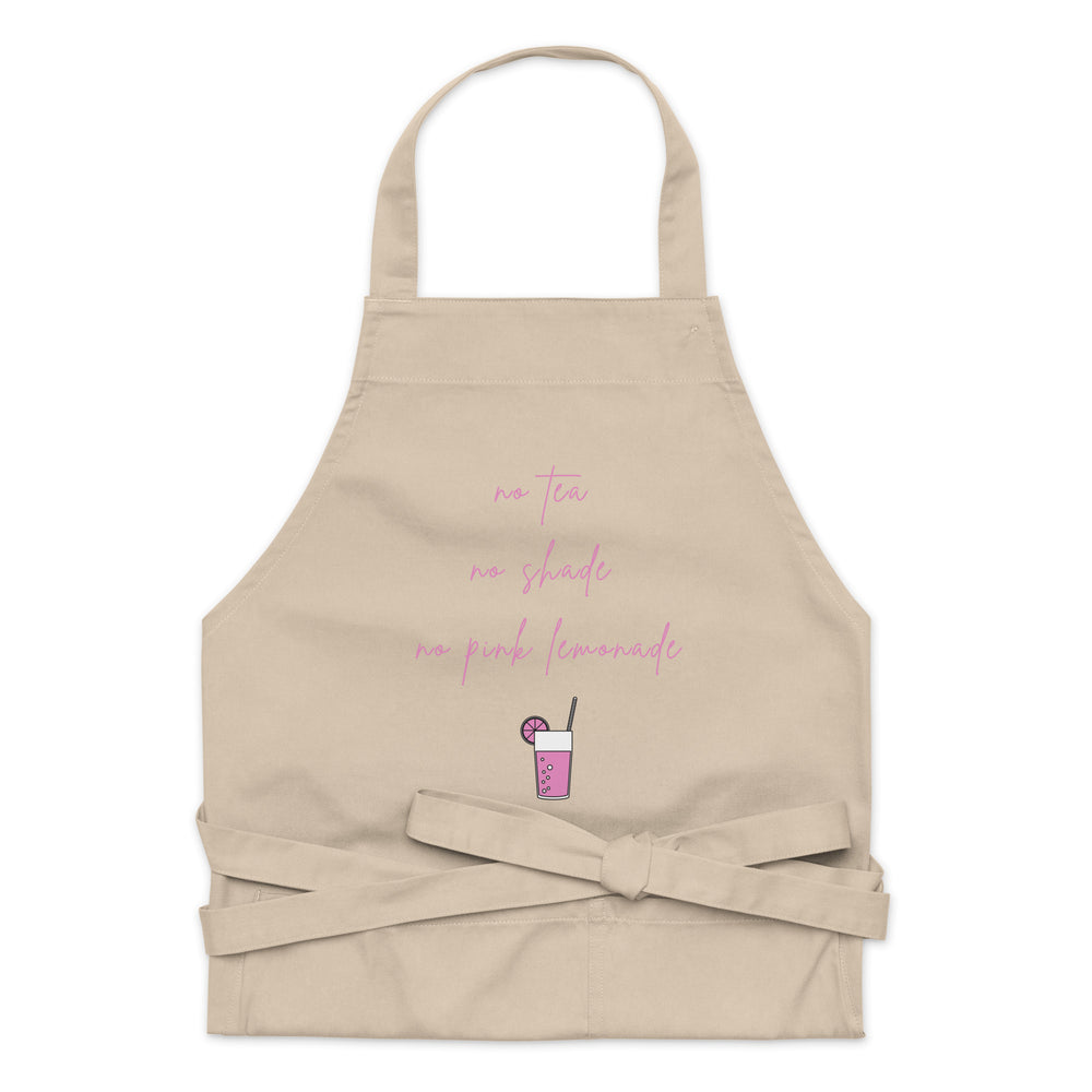 Beige apron with pink script reading “no tea no shade no pink lemonade” and a drink graphic