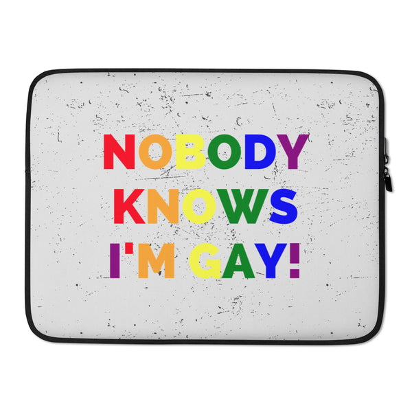 Front view of a gray laptop sleeve reading “NOBODY KNOWS I’M GAY!” in rainbow letters