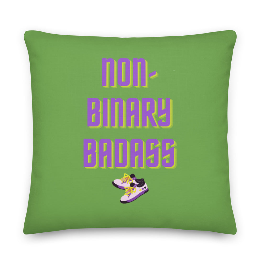 Green square pillow reading “non-binary badass” with illustrated purple sneakers