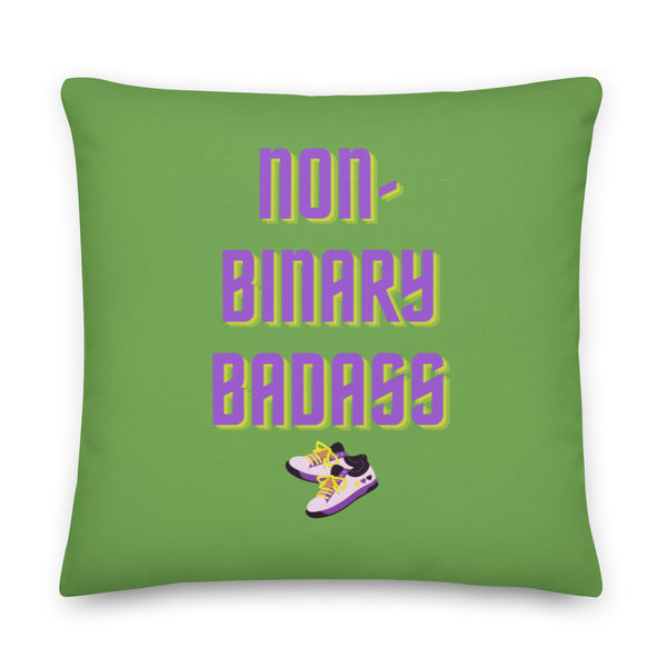 Green square pillow reading “non-binary badass” with illustrated purple sneakers