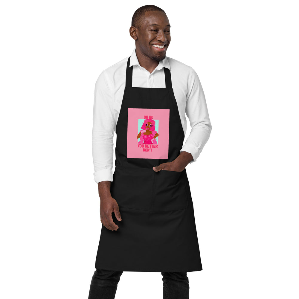 Model wearing a black apron with pink “OH NO YOU BETTER DON'T” graphic