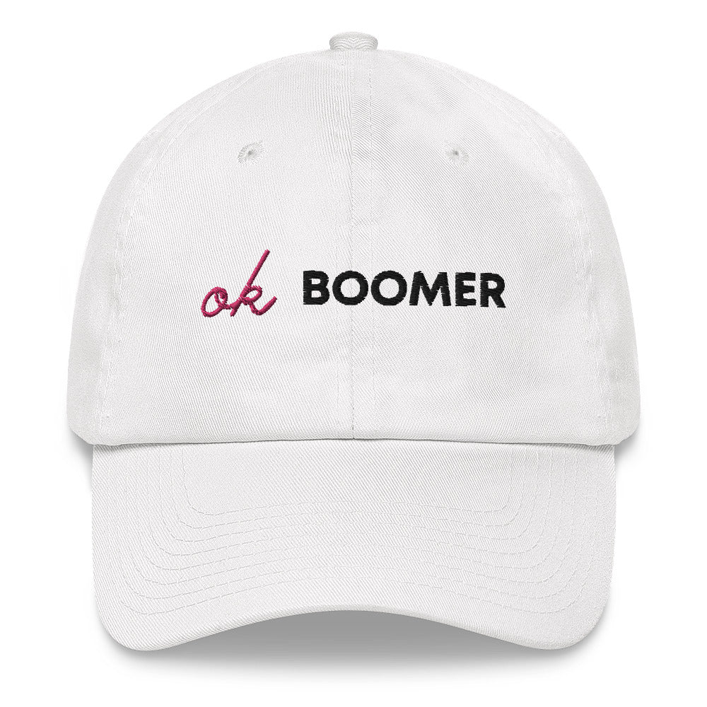 Front-facing white baseball cap embroidered with pink and black “Ok Boomer” text