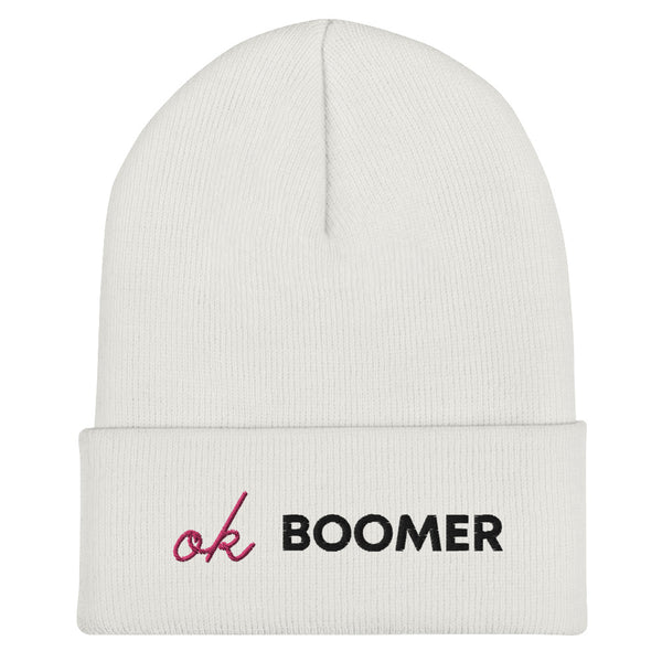 Front view of a white cuffed beanie embroidered with “OK BOOMER” in black and pink