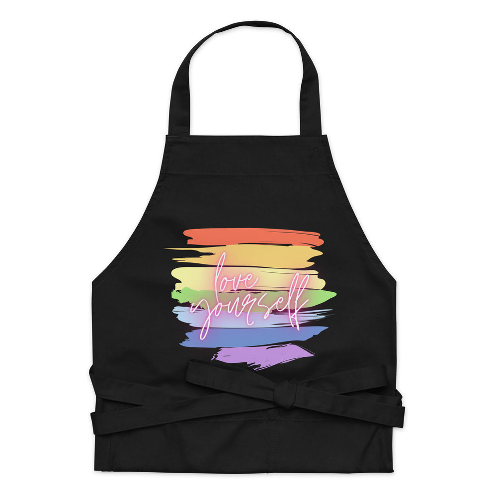 Front view of a black apron with rainbow brushstrokes and “love yourself” text