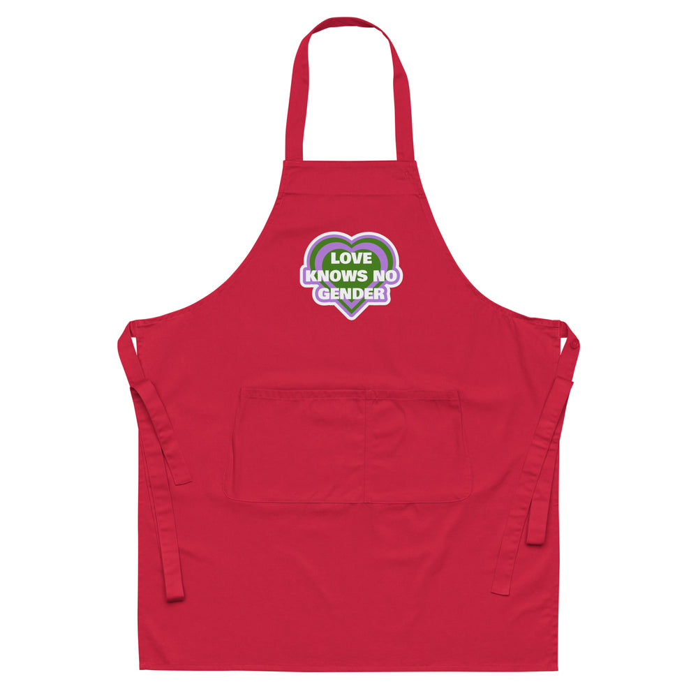 Front-facing red apron with neck strap, waist ties, front pocket, and heart graphic reading “LOVE KNOWS NO GENDER”