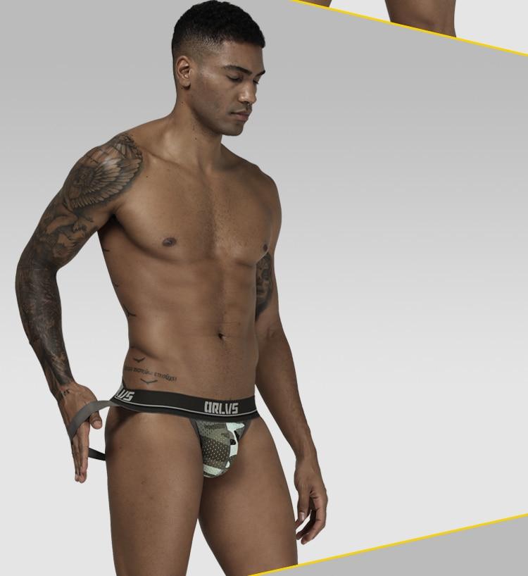 Front view of a model wearing a camouflage mesh jockstrap with a branded waistband