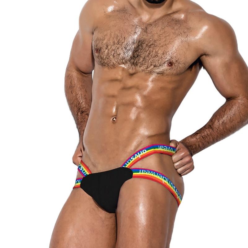 Model wearing a black jockstrap with rainbow Pride waistband and supportive pouch