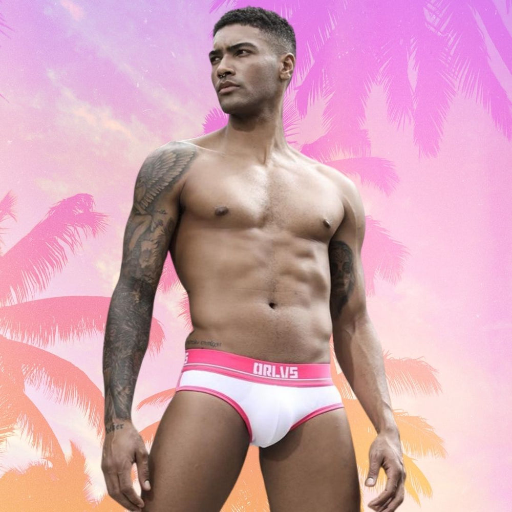 Model wearing white retro pop briefs with pink trim and a branded waistband