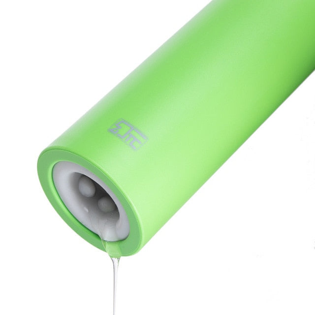 Close-up of a bright green cylindrical penis masturbator with its textured opening visible