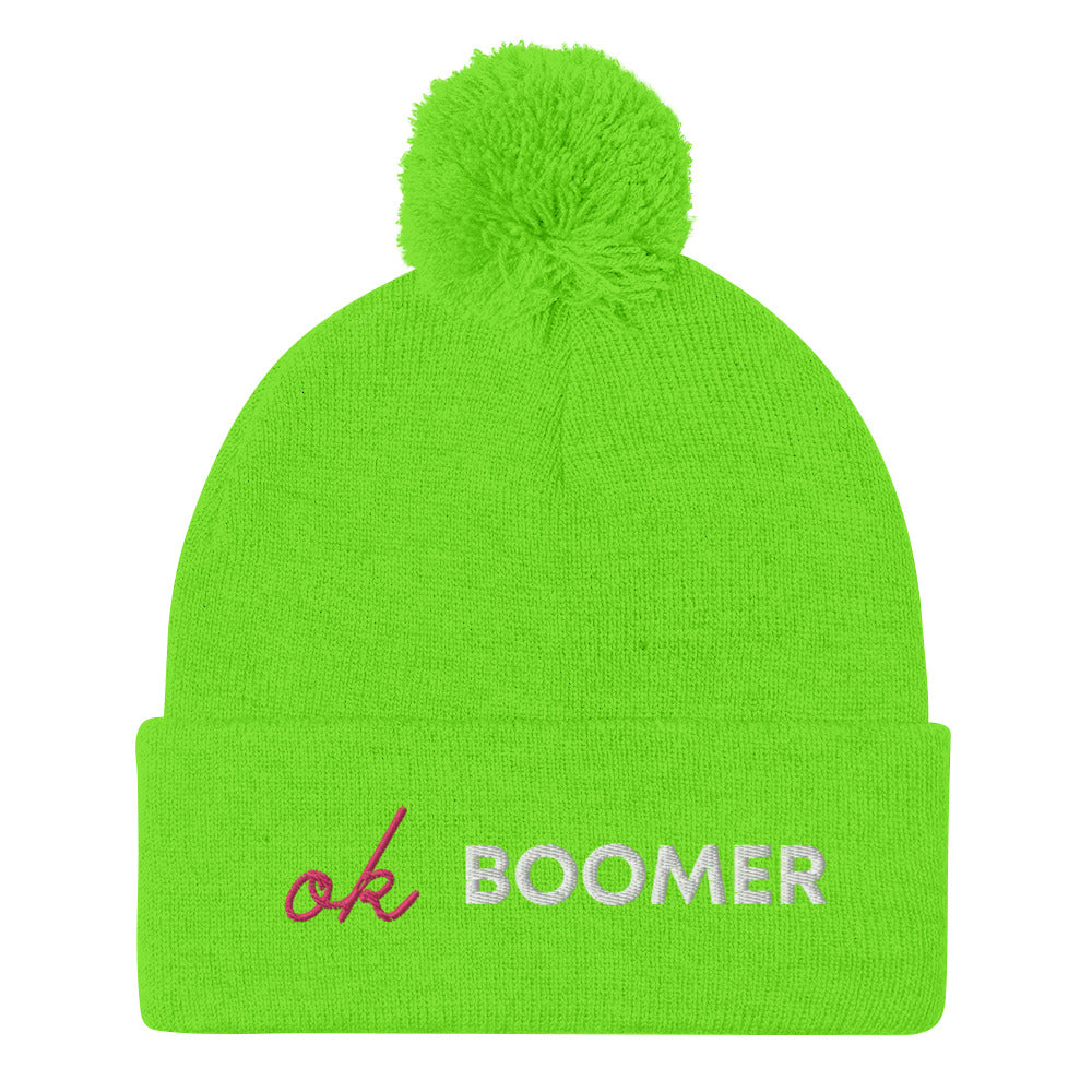 Neon green knit pom-pom beanie with embroidered pink “ok” and white “BOOMER” text