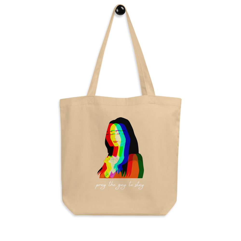 Natural canvas tote bag with rainbow layered woman graphic and “pray the gay to stay” text
