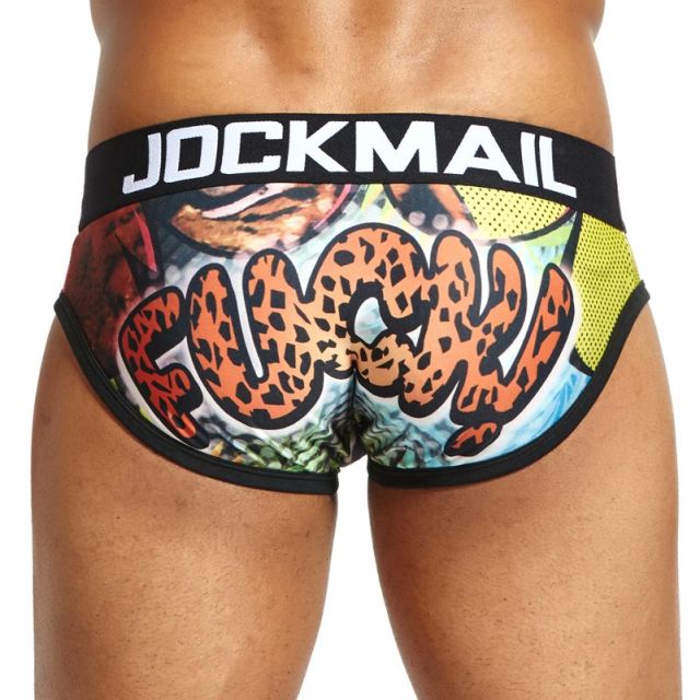 Model wearing Jockmail briefs with orange leopard-print lettering and a black JOCKMAIL waistband
