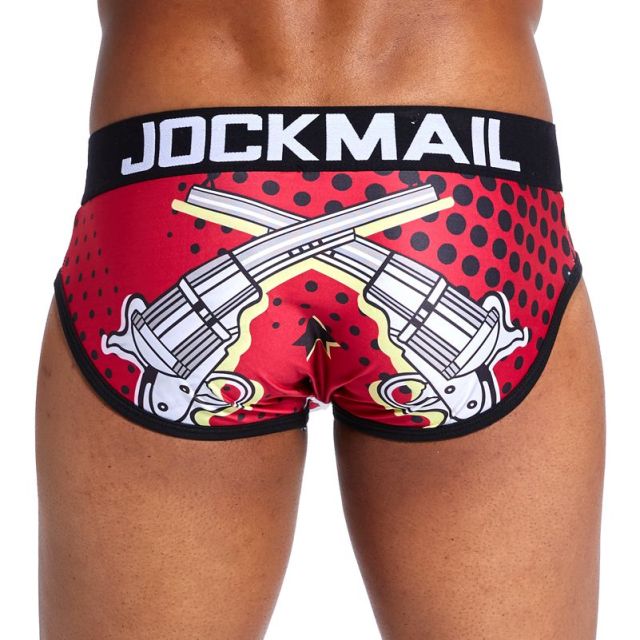 Model wearing red pistol-print Jockmail briefs with a black waistband