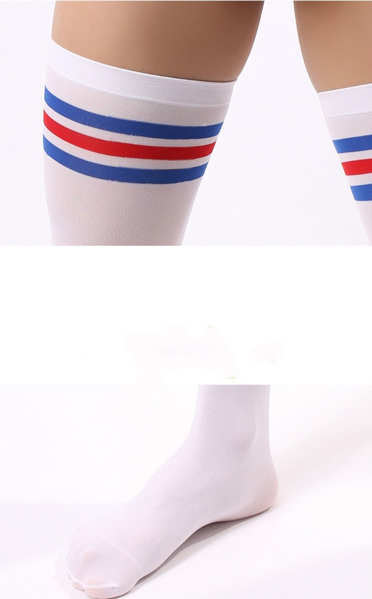 Close-up of white tube sports socks with red and blue stripes worn on legs