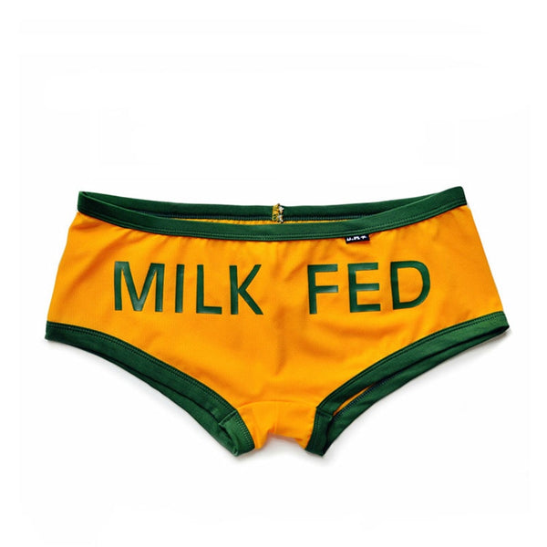 Orange and green “MILK FED” boxer briefs laid flat on a white background