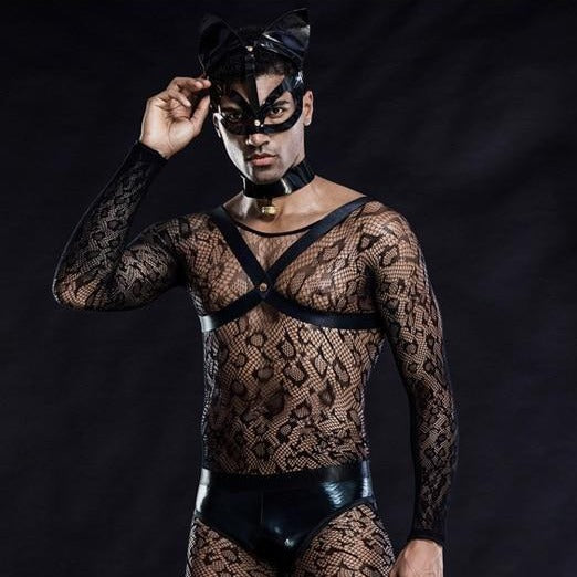 Model wearing a black mesh cat costume with mask, harness straps, collar, and shiny briefs