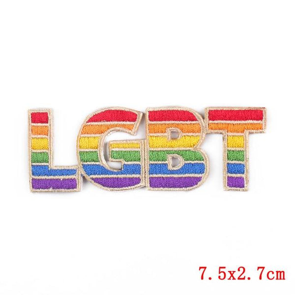 sklep online lgbtqia: Flat lay of rainbow LGBT Pride embroidered iron-on patches, rainbow flags, buttons, beads