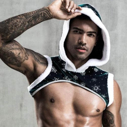 Shirtless tattooed model wearing a black snowflake-trimmed hooded Christmas crop top