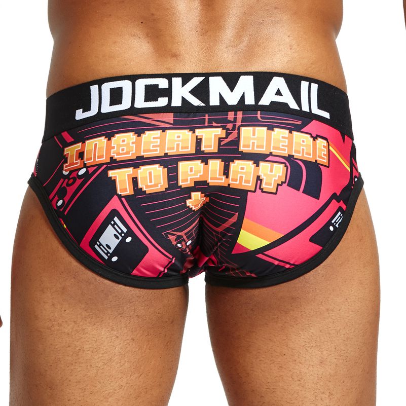 Model wearing black briefs with neon arcade graphics and “INSERT HERE TO PLAY” text