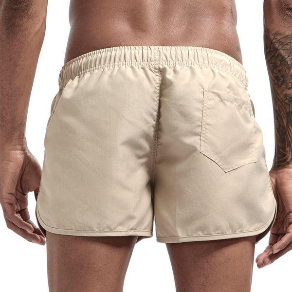 Rear view of khaki swim shorts with elastic waistband, curved hems, and a back patch pocket