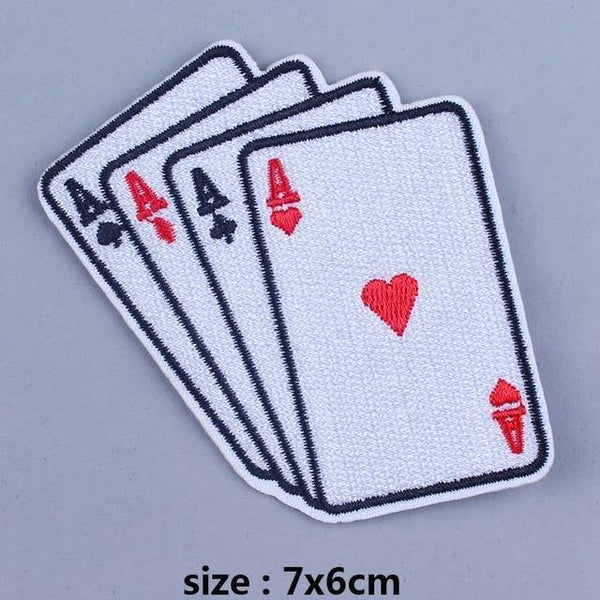 Close-up of four embroidered playing-card patches with aces and a red heart, 7 by 6 cm
