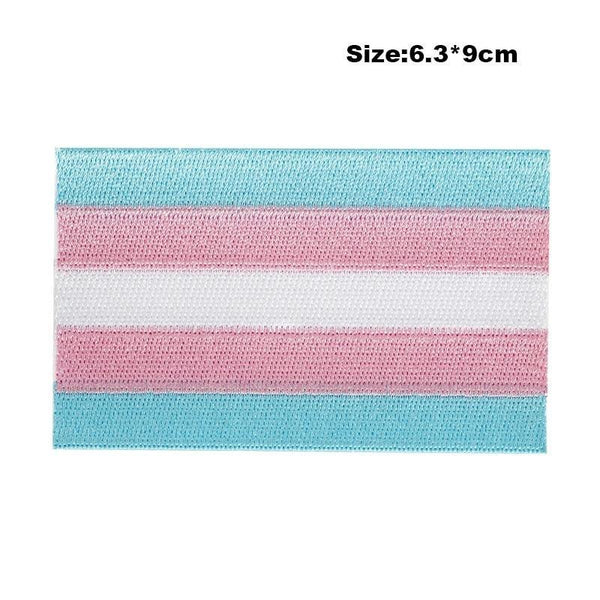 Close-up of a transgender pride embroidered patch with blue, pink, and white stripes